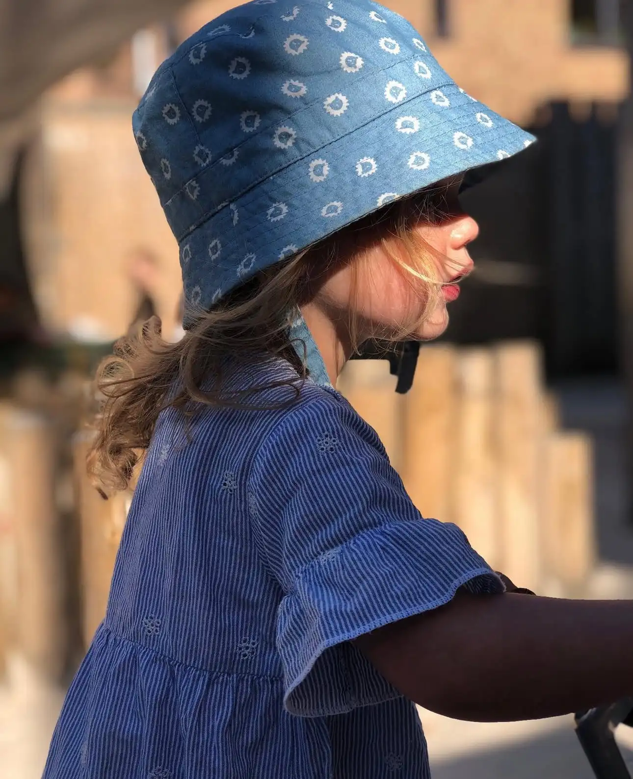 Kind met blauw zonnehoedje speelt buiten bij Kideo