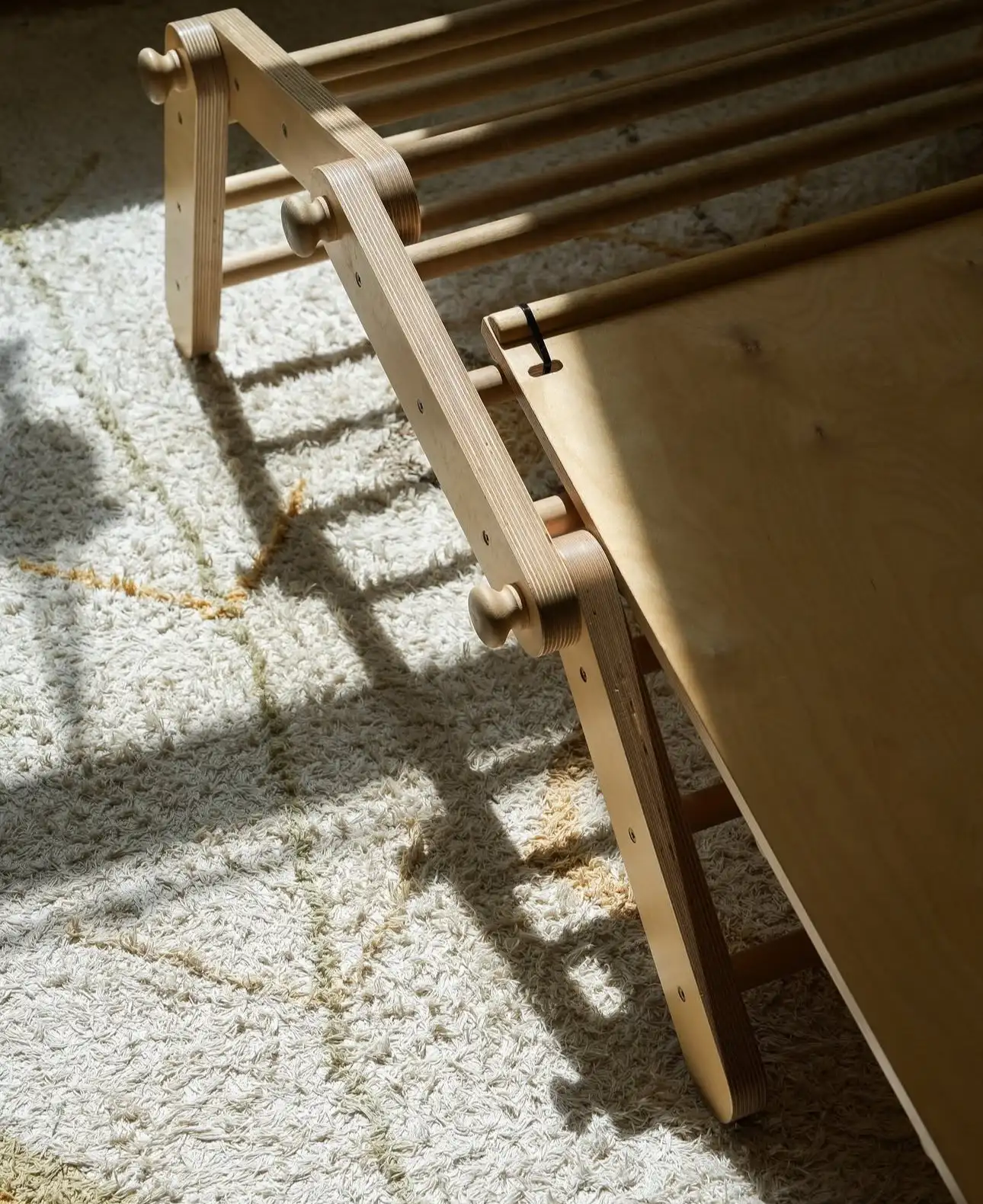 Houten klimrek met glijbaan op een zacht vloerkleed bij Kideo